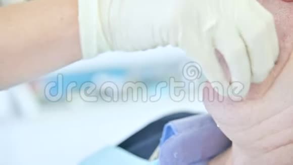 口腔科医生的一个特写镜头从他的口腔中取出一种聚合形式供一个年老的病人使用以制造一假体视频的预览图