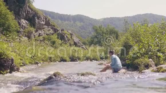 山河流水女子坐石岸低视角视频的预览图