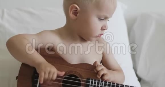 一个可爱的孩子摸乐器上的弦视频的预览图