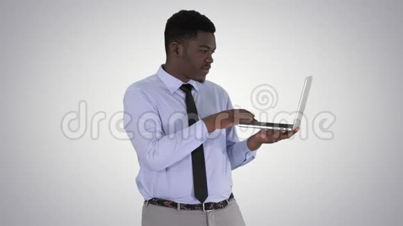 和一个拿着笔记本电脑在渐变背景下拍照的非洲年轻人交谈视频的预览图