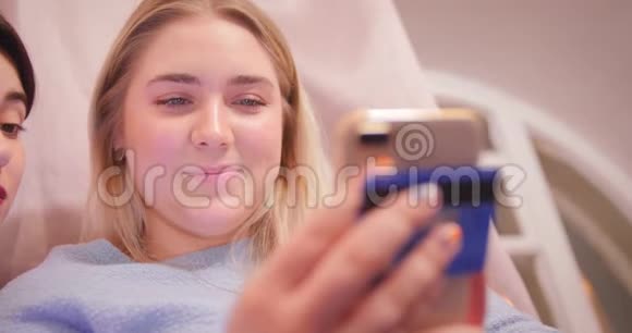 金发女孩通过互联网商店的电话用信用卡付款网上购物时尚微笑视频的预览图