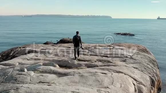 一个男摄影师在海边慢镜头拍摄的照片视频的预览图