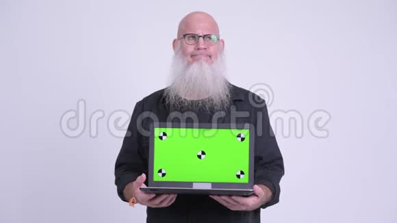 一个成熟的秃头男人一边看着笔记本电脑一边思考视频的预览图