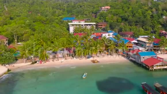 柬埔寨KohRong的热带海岸传统色彩鲜艳的房屋被白色海滩和棕榈树包围视频的预览图