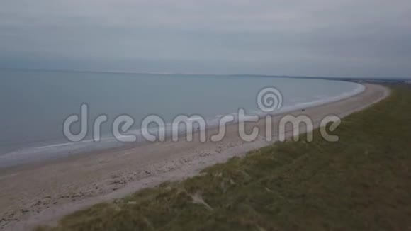 美丽的海滩和美丽的绿色田野令人惊叹的海景人们在海滩上奔跑从空中拍摄视频视频的预览图