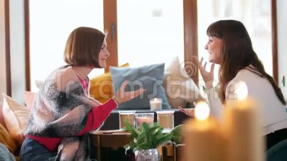 两个年轻的女人坐在咖啡馆里聊天侍应生端着煎饼视频的预览图