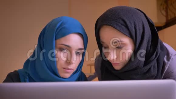 年轻美丽的穆斯林女商人用笔记本电脑在室内讨论工作主题的特写肖像视频的预览图