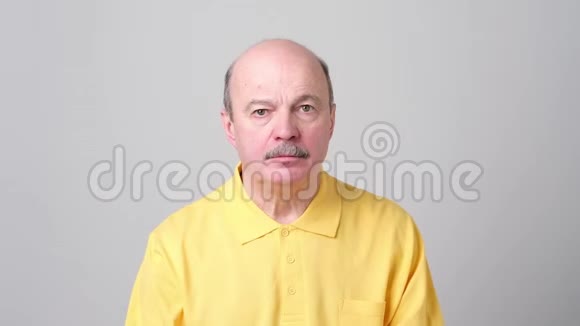 成熟的白种人男人穿着蓝色衬衫做着沉默的手势视频的预览图