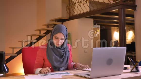 年轻的穆斯林女性雇员和雇主在笔记本电脑前讨论图表上的数据的特写照片视频的预览图