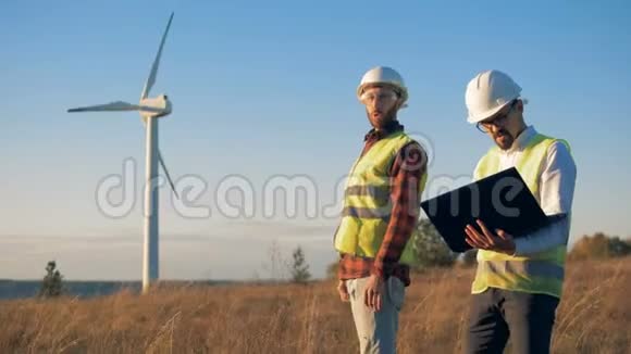 工人们在田里检查风车走路可再生电能绿色能源概念视频的预览图