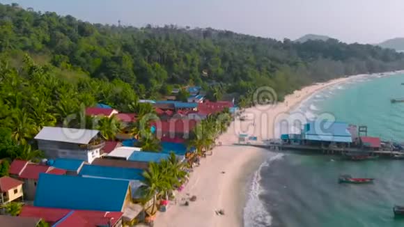 柬埔寨KohRong的热带海岸传统色彩鲜艳的房屋被白色海滩和棕榈树包围视频的预览图