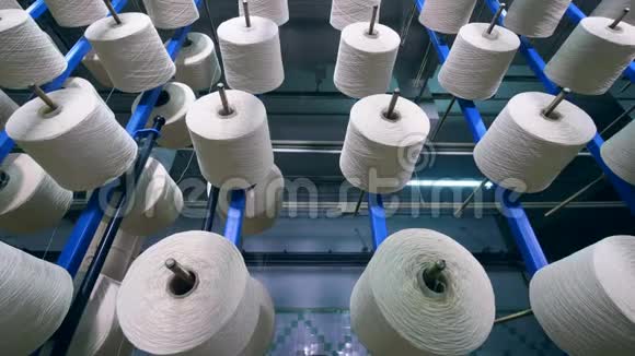 在纺织厂的特殊机架上将线卷到筒管上的过程视频的预览图