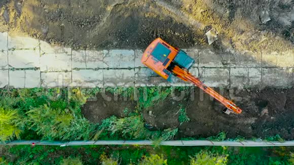 挖掘机在毛虫在基坑施工期间进行建筑物基础挖高空俯视图视频的预览图