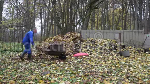 农夫提着装满树叶的手推车袋子把它倾倒在堆肥堆上4K视频的预览图