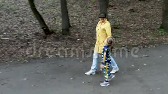 一位美丽的母亲和她可爱的小女儿在公园里散步视频的预览图