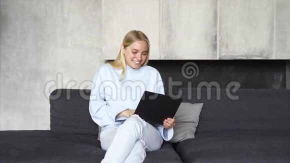 女人早上在房间的沙发上用笔记本电脑工作视频的预览图