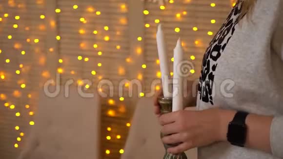 女人或女孩用手装饰圣诞或新年晚餐的桌子手把蜡烛放在节日的烛台上视频的预览图