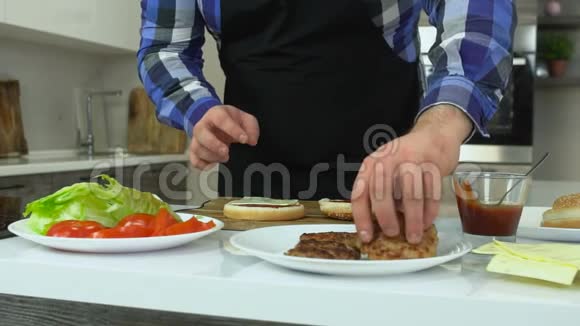 超重的男人在家做汉堡包胖子把肉排放在面包上不健康的生活方式油炸和高热量视频的预览图