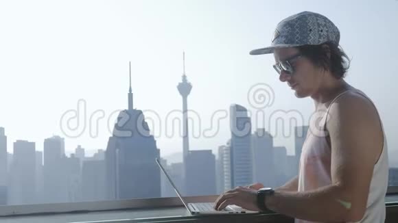 暑假期间在现代城市背景下使用笔记本电脑的自由职业者视频的预览图