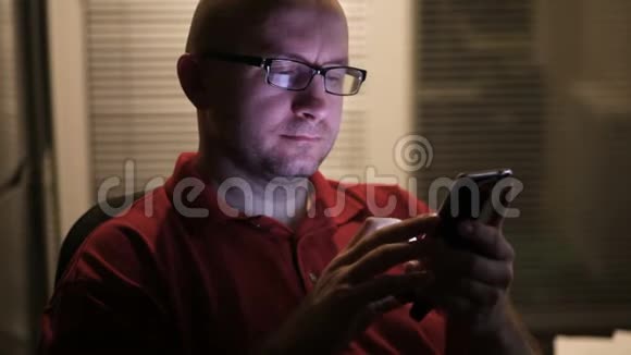 一名男子站在酒店房间靠窗的位置使用智能手机视频的预览图