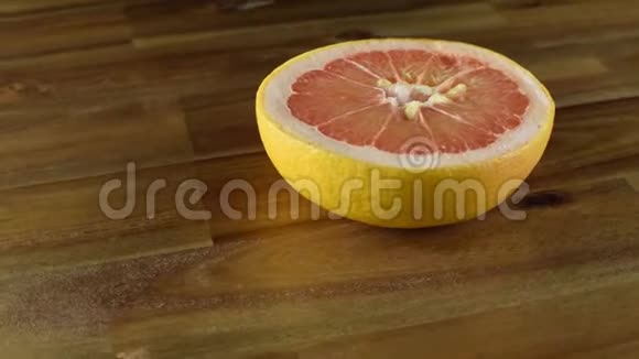 半个红葡萄柚在木桌上旋转视频的预览图