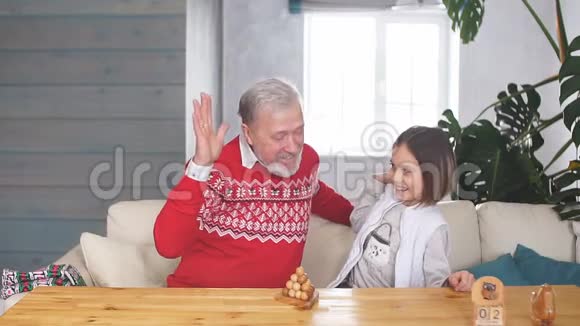 快乐的爷爷在屋里和孙女玩游戏视频的预览图