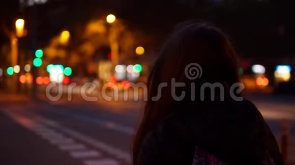 年轻女子独自一人在市中心夜间穿过马路视频的预览图