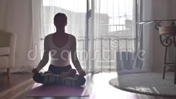 健康的女人在早晨用莲花姿势做瑜伽练习视频的预览图