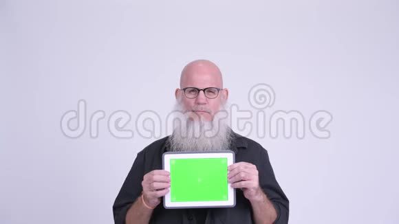 成熟的秃头男人一边看着数码平板电脑一边震惊视频的预览图