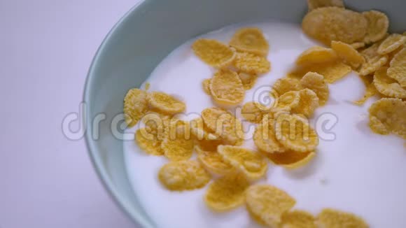 特写镜头甜蜜的早餐碗麦片和牛奶用手蘸一勺美味的美餐视频的预览图