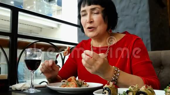 优雅的高级女人在餐馆或咖啡馆里吃沙拉视频的预览图