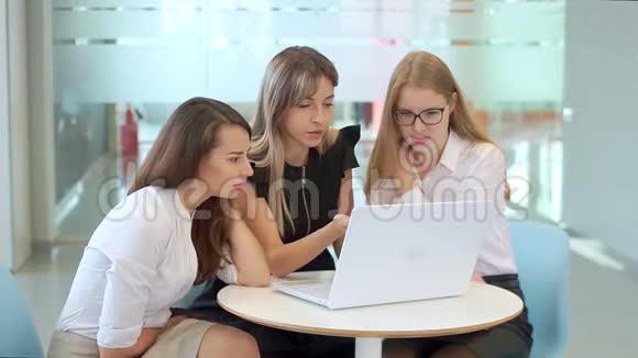 女生在办公室进行业务培训有兴趣看笔记本电脑视频的预览图