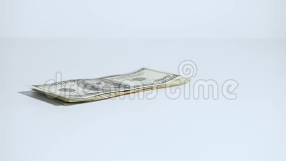 一叠美元落在桌子上一个人手拿着它视频的预览图