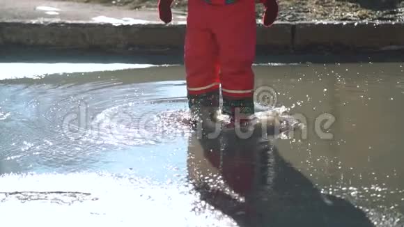 小女孩蹦蹦跳跳地跳进水坑里视频的预览图