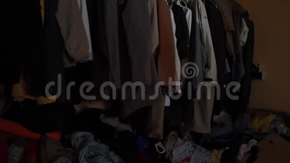 肮脏的地板上躺着一堆堆二手衣服的整洁的衣橱视频的预览图