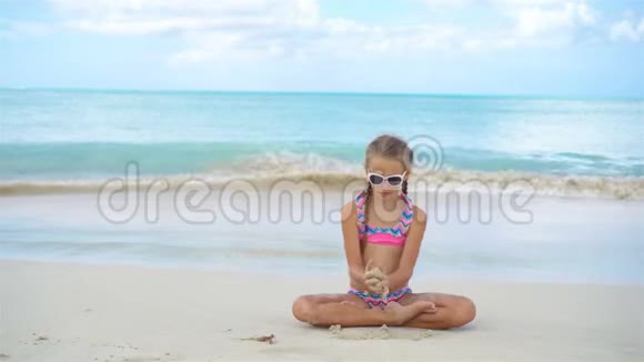 可爱活泼的小女孩在雪白的沙滩上视频的预览图