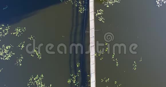 木桥隔着一条河通向河上一座孤零零的房子视频的预览图