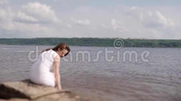 女孩坐在河岸上视频的预览图