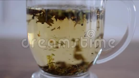 关闭植物茶茶叶倒在玻璃的底部视频的预览图