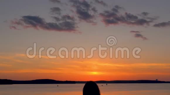 幸福的女人在红霞夕阳下举起双臂视频的预览图