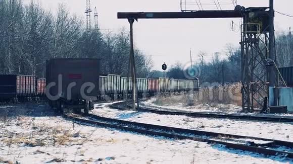 柴油火车和货车沿着积雪覆盖的火车站行驶视频的预览图