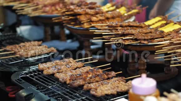 慢动作在热烤架上准备小美味的烤肉串泰国传统食品街市场视频的预览图