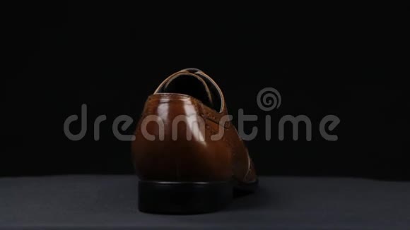 旋转一个时尚的经典棕色鞋带在黑色背景视频的预览图