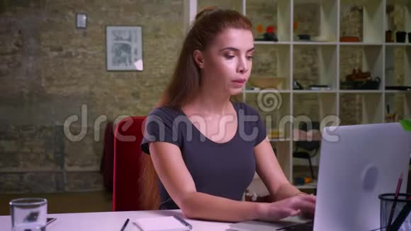 拍摄工作中的白种人红发女性集中精力工作坐着做笔记检查视频的预览图