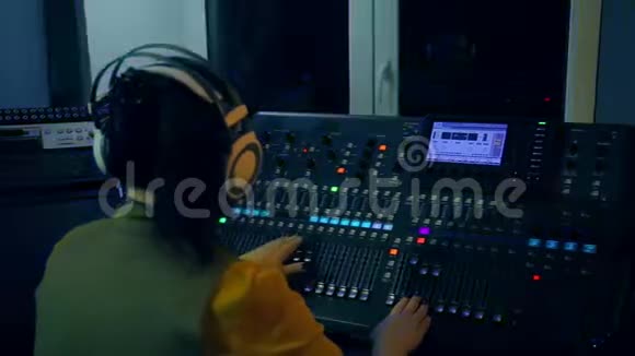 女DJ在彩色照明混合控制台工作视频的预览图