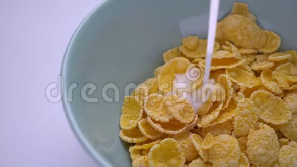 早餐碗里倒着玉米片的牛奶特写镜头视频的预览图