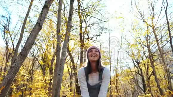 快乐的年轻女子在秋天的森林里玩得很开心视频的预览图