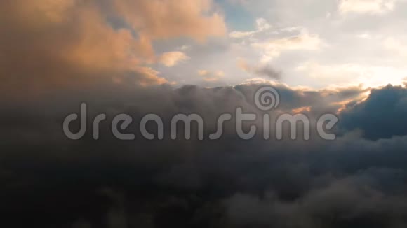 在云层上方的夕阳下用照相机穿过傍晚的雨云在云层中飞行得很棒空中景观视频的预览图