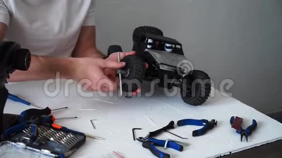修理无线电控制模型车的人桌子上有修理工具视频的预览图