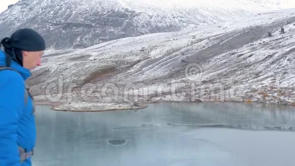 旅行者站在一个高点在智能手机上拍摄一个美丽的佩扎兹山脉和湖泊视频的预览图
